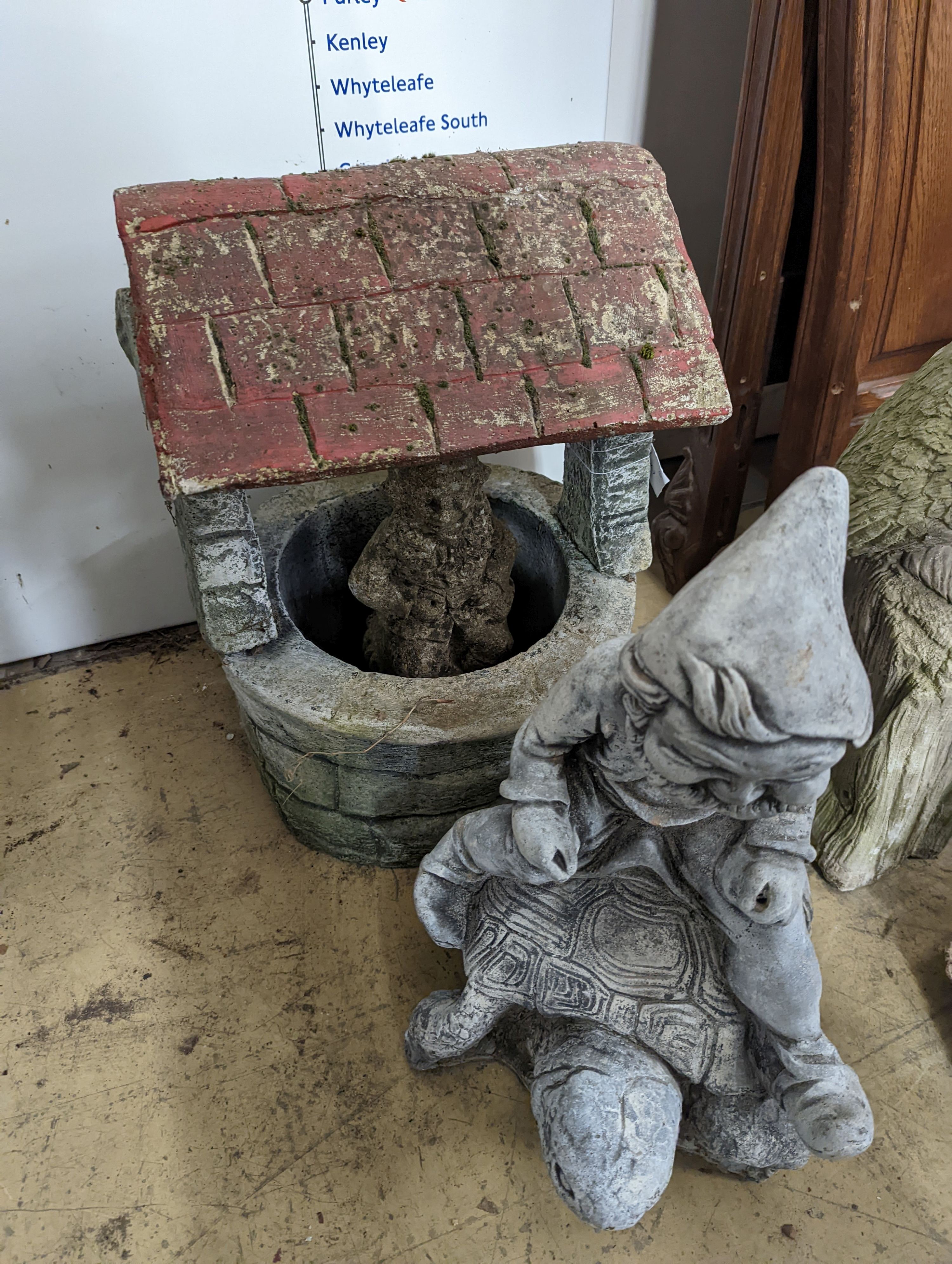 A reconstituted stone well garden ornament and two stone garden gnome ornaments, largest height 50cm
